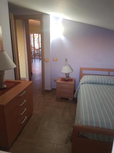 una camera con 2 letti e una lampada su un comò di Appartamento Marinella a Pizzo