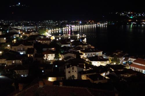 a city at night with lights on the water at Snegar Apartments in Ohrid