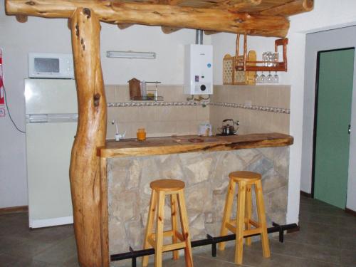 une cuisine avec un comptoir et deux tabourets dans l'établissement Posada del Angel, à San Carlos de Bariloche