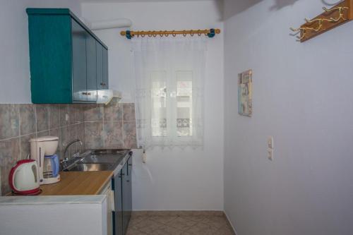 a kitchen with a sink and a window at Studios Nelli Alonissos in Patitiri
