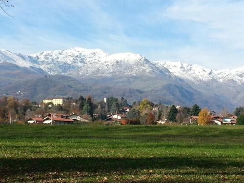 a field with snow capped mountains in the background at Antica Cascina del Medico in Muzzano