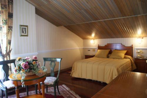 a bedroom with a bed and a table with flowers on it at My Rooms City Hotel Camino de Santiago in Castrillo del Val