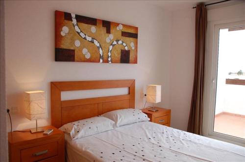 a bedroom with a bed and two night stands with lamps at Golf Course View Penthouse in El Romero