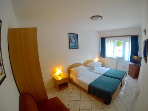 a bedroom with a bed and a chair and a window at Apartment Dragun in Pula