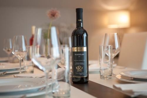 a bottle of wine sitting on a table with glasses at Hotel Riva by Aycon in Petrovac na Moru