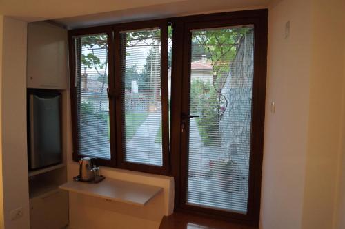 a bathroom with two windows with blinds on them at Snegar Apartments in Ohrid