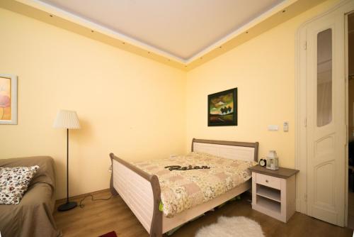 1 dormitorio con 1 cama, 1 mesa y 1 lámpara en Rox Central Apartments 2, en Timisoara