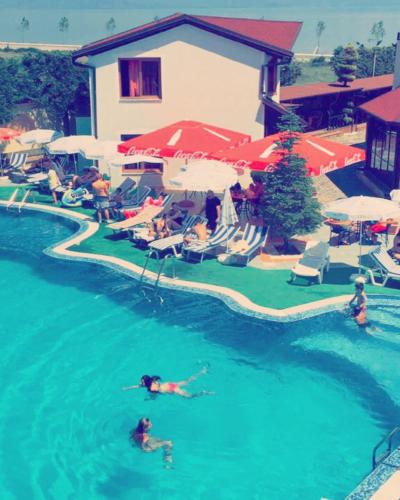 two people swimming in a pool at a resort at Hotel Lyhnidas in Pogradec