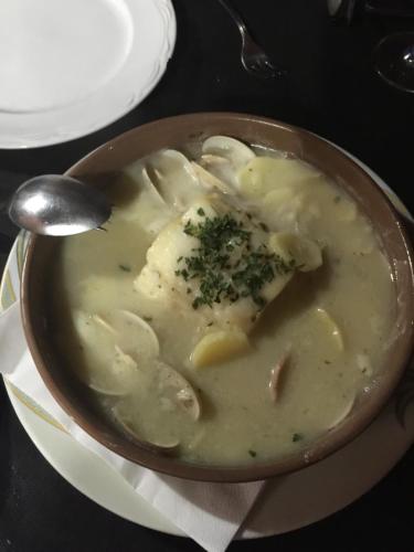 a bowl of chicken and dumpling soup with a spoon at Hotel Rural Casa Migio in Urbiés
