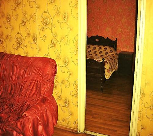 a bedroom with a bed and a couch and a mirror at Hotel Lilo near Airport in Tbilisi City