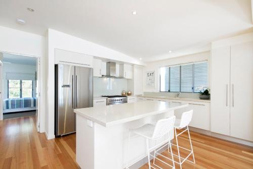 a kitchen with white cabinets and a white counter top at Tranquil & Modern Riverside Getaway in Noosaville