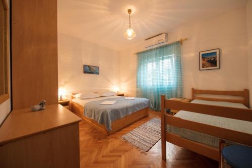 um pequeno quarto com 2 camas e uma secretária em Apartmani Fiamengo em Komiža