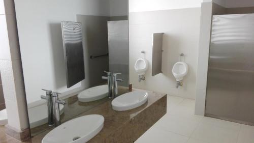 a bathroom with three toilets and three urinals in it at Apartamento con salida al Mar in Santa Marta