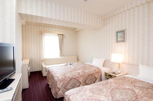 Tempat tidur dalam kamar di Hotel Unisite Mutsu