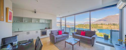 a living room with two chairs and a large window at Swiss-Belsuites Pounamu Queenstown in Queenstown
