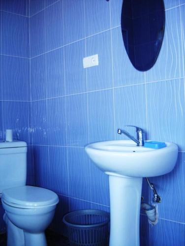 a blue bathroom with a sink and a toilet at Hotel Lilo near Airport in Tbilisi City