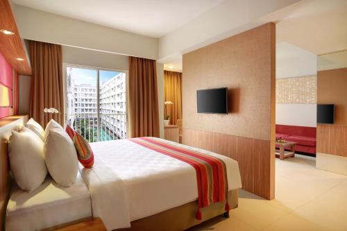 um quarto de hotel com uma cama e uma varanda em Kyriad Hotel Airport Jakarta em Tangerang