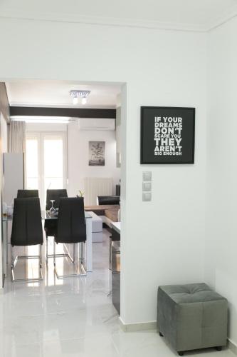 a living room with a table and black chairs at Route 77 in Thessaloniki