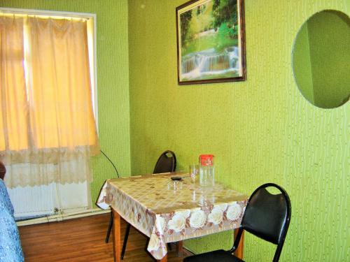 a dining room table with two chairs and a table with glasses at Hotel Lilo near Airport in Tbilisi City