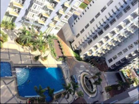 een uitzicht op twee hoge gebouwen en een zwembad bij One Palm Tree Villas by Mary in Manilla