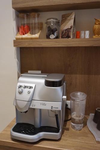 a coffee maker on a shelf with a glass at Ecology River in Dongshan
