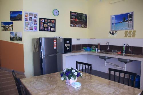 a kitchen with a table with flowers on it at Sun Inns Rest House Kuantan in Kuantan