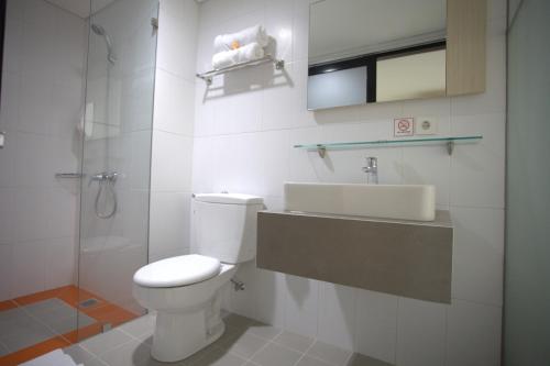 La salle de bains est pourvue de toilettes, d'un lavabo et d'une douche. dans l'établissement Wanadu Residence, à Tangerang