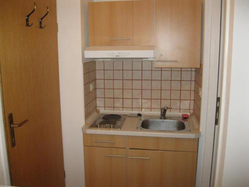a small kitchen with a sink and a stove at Apartments Lav Poreč in Poreč