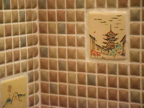 a tile wall with chinese tiles on it at Guesthouse Higashiyama in Kyoto