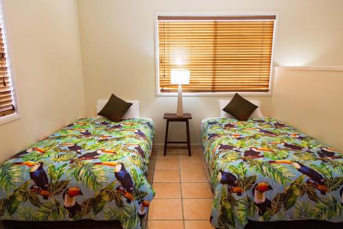 a bedroom with two beds and a window at White Lace Motor Inn in Mackay