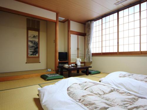 木曽町にある木曽文化公園 宿泊施設 駒王のベッド2台とテレビが備わる客室です。