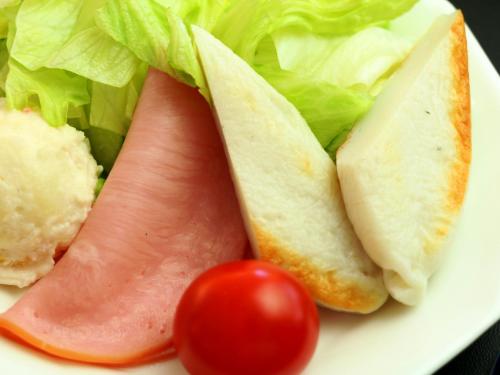 a plate with a sandwich and a tomato and lettuce at Komao in Kiso