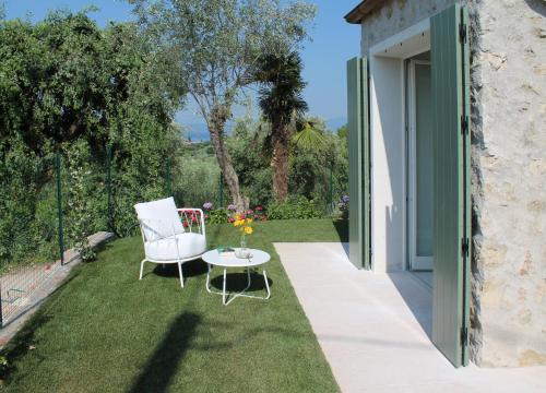 a patio with two chairs and a table on the grass at Ca Muretta Relais in Bardolino