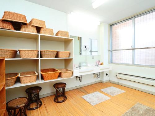 a bathroom with baskets on shelves and a sink at Komao in Kiso