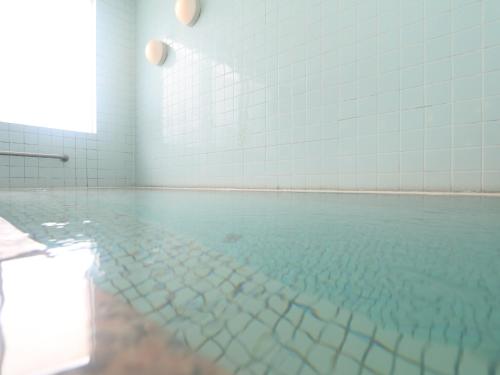 an empty swimming pool with blue tiles on the wall at Komao in Kiso