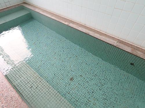 a pool of water in a bathroom with a tile floor at Komao in Kiso
