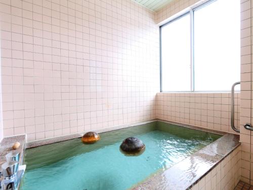 une baignoire avec deux balles dans l'eau dans l'établissement Komao, à Kiso