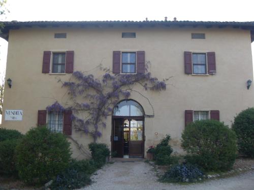 Monte San PietroにあるAgriturismo Montevecchio Isolaniの赤いシャッター付きの窓と扉のある家