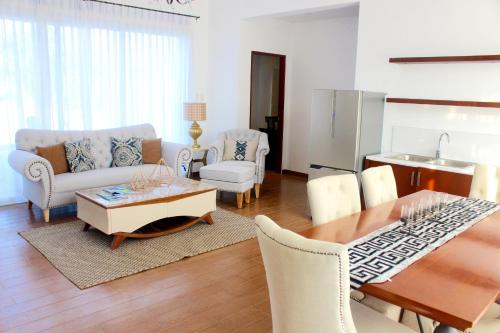 a living room with a table and chairs and a kitchen at Thunderbird Resorts - Poro Point in San Fernando