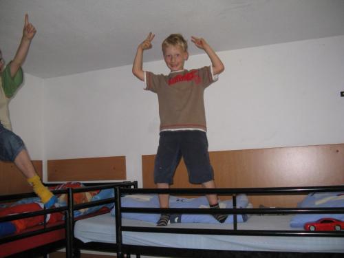 a young boy jumping on top of a bunk bed at Hostel Schweriner See in Retgendorf