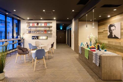 a lobby with a counter and chairs and a table at Belken Hotel Tokyo in Tokyo