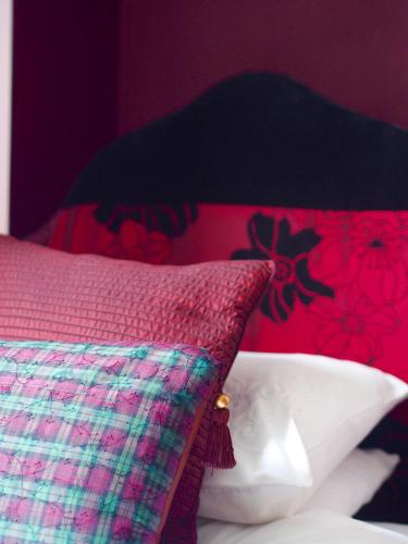 a bedroom with a bed with a pink and green pillow at Wrangham House in Filey