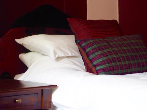 a group of pillows sitting on top of a bed at Wrangham House in Filey