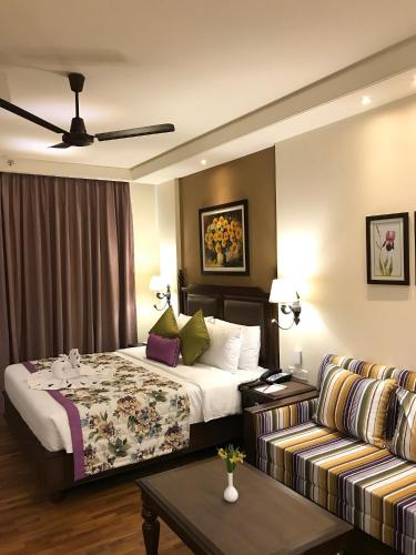 a hotel room with a bed and a couch at Club Mahindra Pristine Peaks Naldehra in Shimla