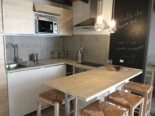 カターニアにあるPiede-à-terre apartmentのキッチン(木製テーブル、いくつかの椅子付)