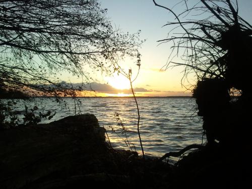 a sunset over a body of water with trees at Ferienpark Retgendorf in Retgendorf