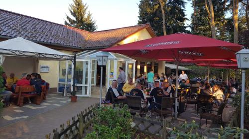 a group of people sitting at a restaurant under umbrellas at Ferienpark Retgendorf in Retgendorf