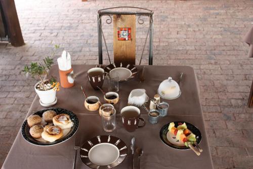 una mesa con platos de comida encima en Ikhamanzi B&B, en Vereeniging