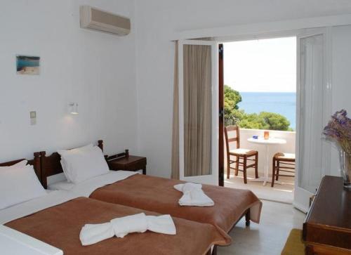 a hotel room with two beds and a balcony at Hotel 3 Adelfia in Agia Marina Aegina