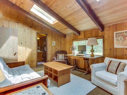 a living room with wooden walls and a wooden ceiling at The Chalet on Lopez in Islandale